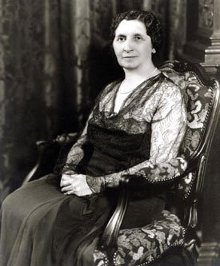 黑白照片，玛蒂尔达道奇威尔逊坐在一个华丽的椅子上。
