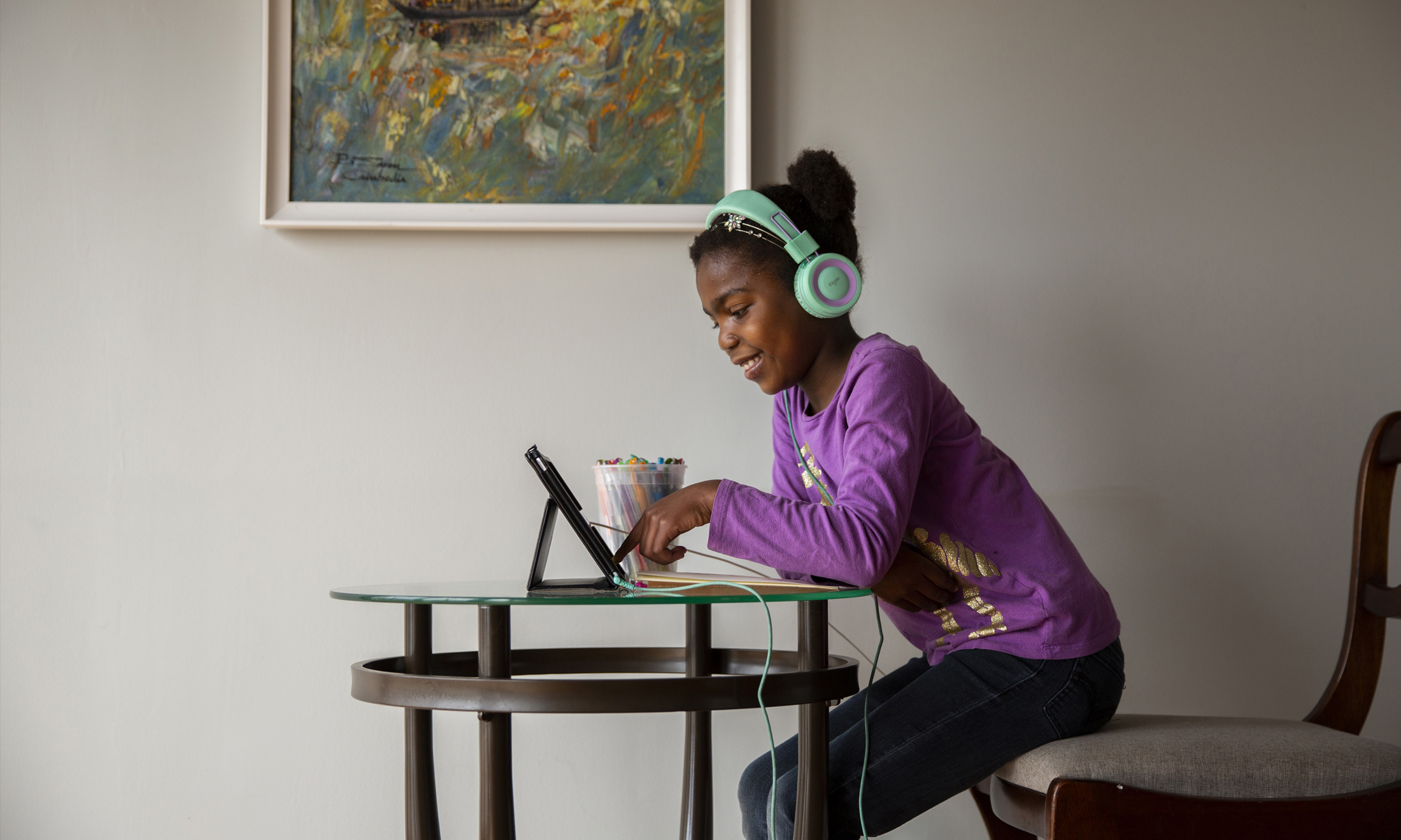 图像的一个小孩戴着耳机坐在电脑前和微笑