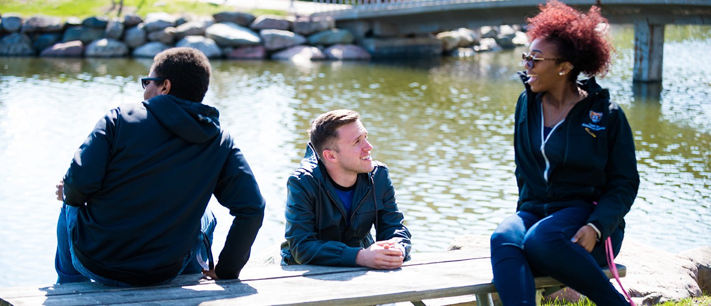 三个学生坐在野餐桌上的熊在奥克兰大学湖。万博ManBetX登录
