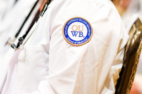 一个特写OUWB补丁的白色外套。