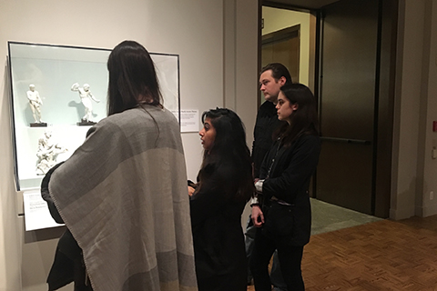 在底特律艺术学院，学生们正在观察玻璃柜里的白色雕塑