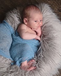 婴儿裹在蓝色毯子里的照片