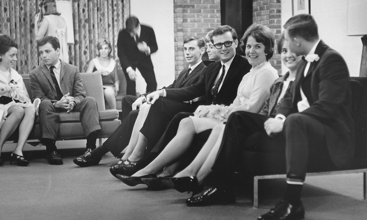 一群穿着上世纪60年代传统服饰的人坐在沙发上