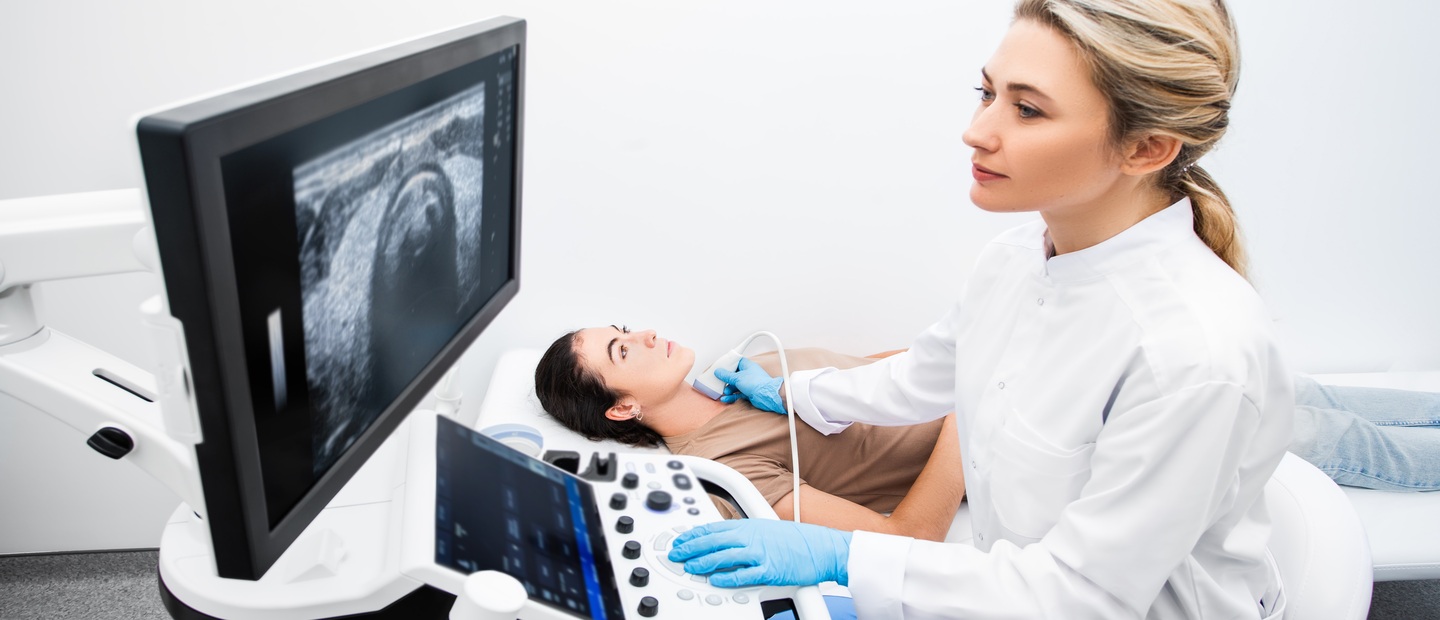 超声波检验师成像一个女人的喉咙。