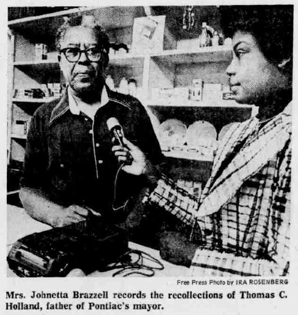 jonetta Brazzell带着录音机和麦克风采访Thomas C. Holland。
