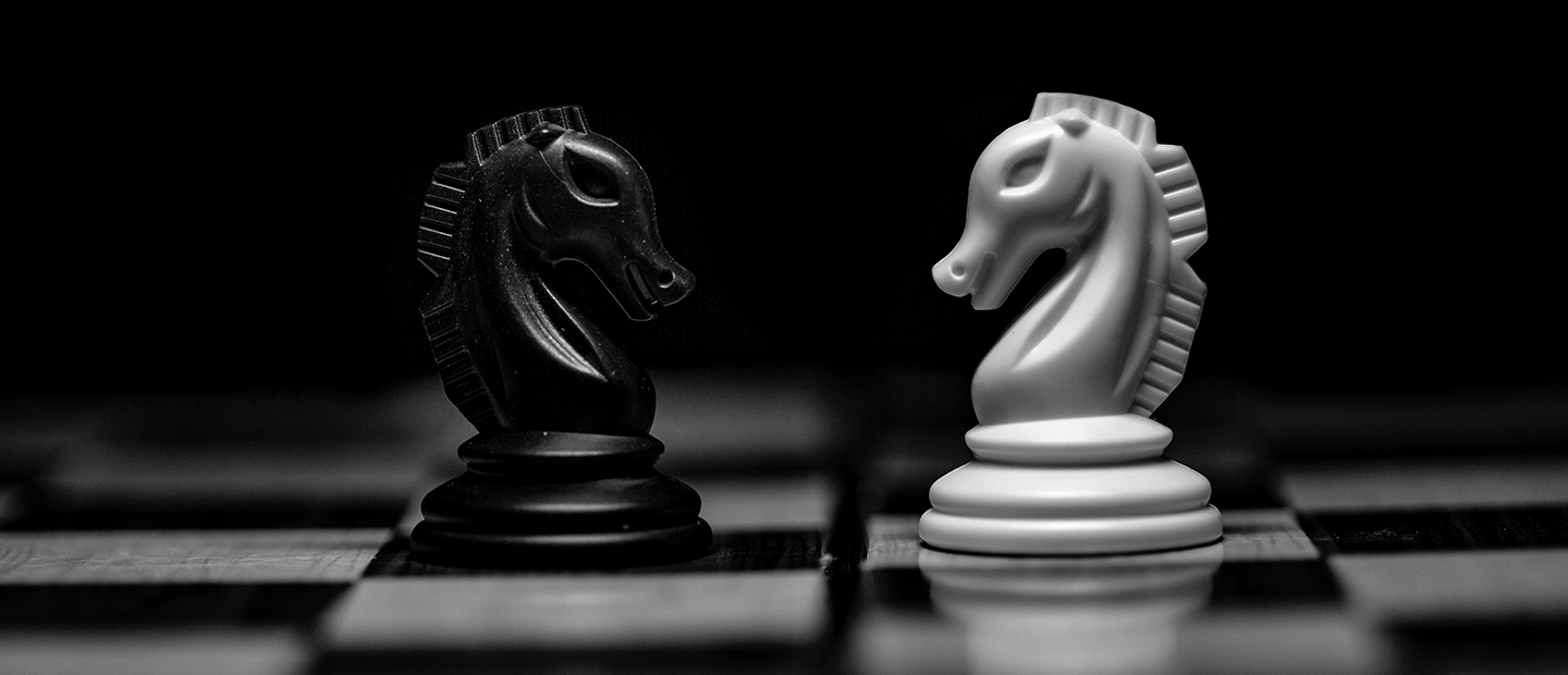 两件骑士面对面在棋盘上,一个是黑人一个是白人。