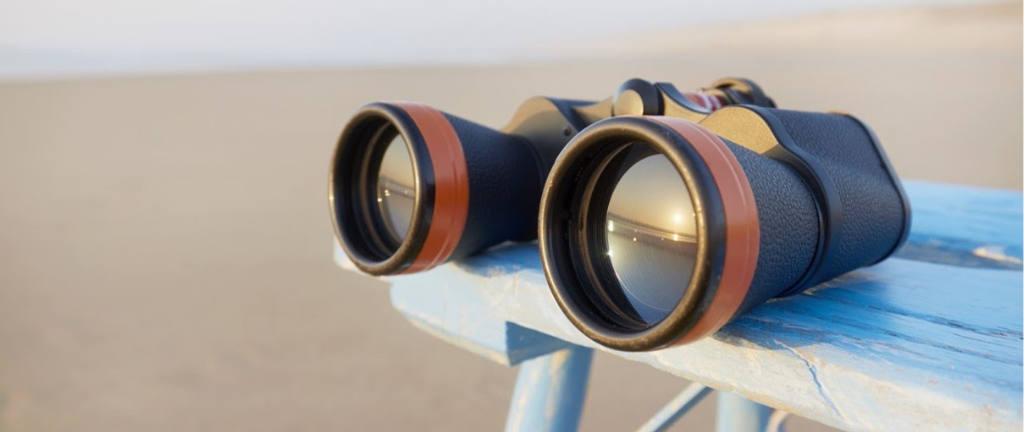 在海滩上双筒望远镜在长椅上