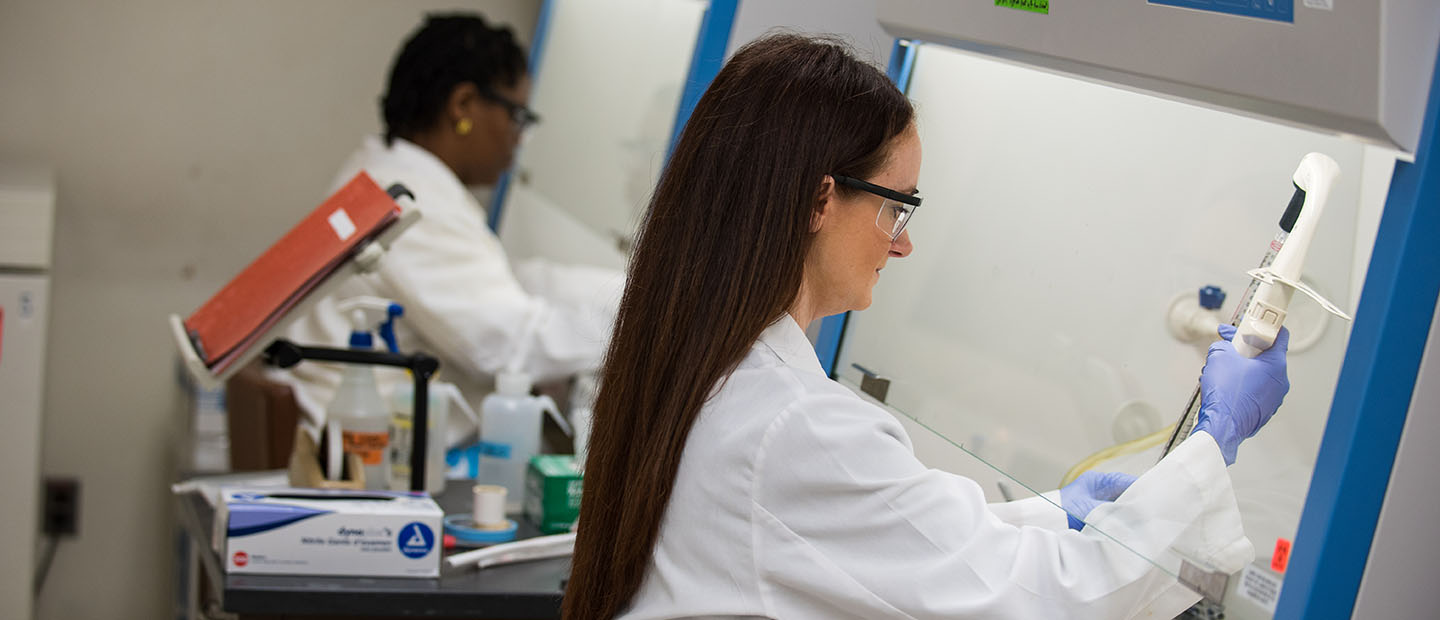 两个穿着白大褂的女人在实验室里使用设备