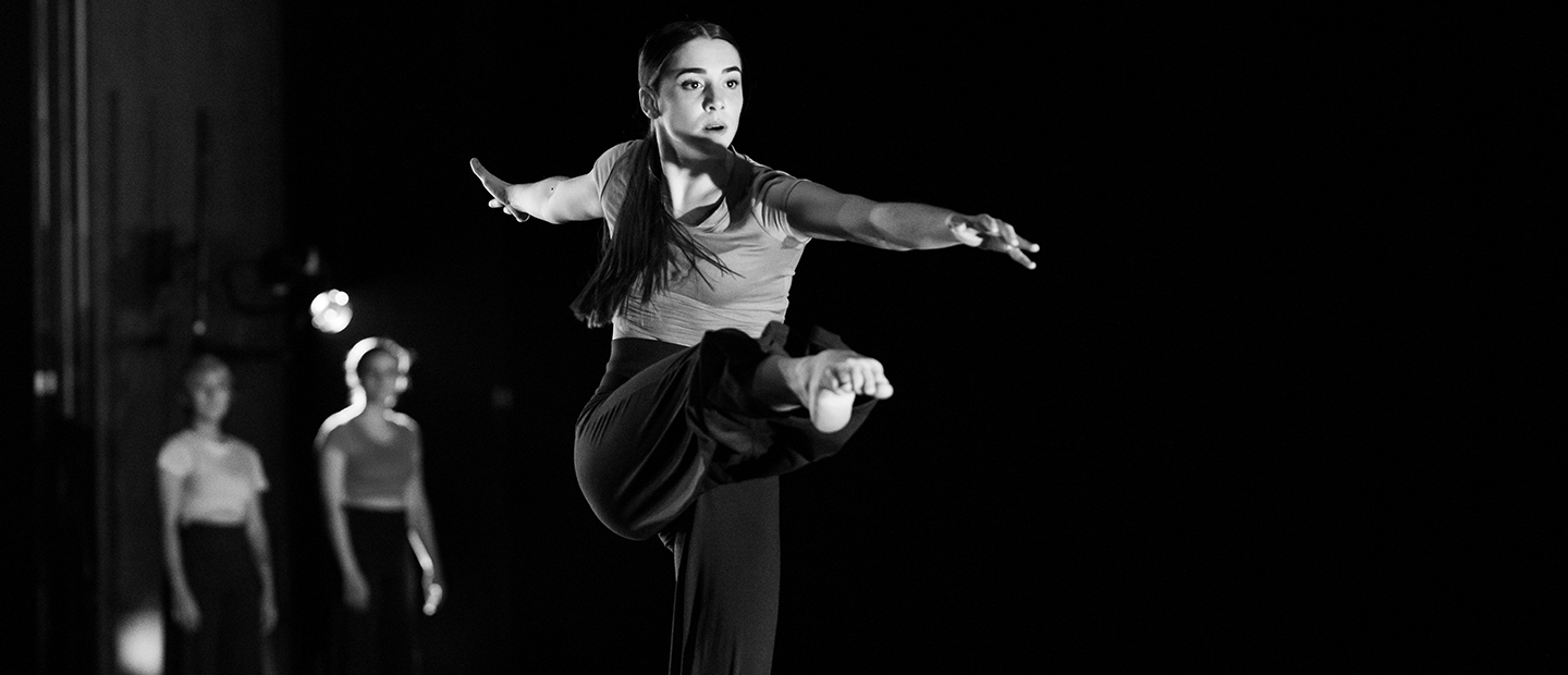 一个独舞女舞者的形象在舞台上与她的腿伸展