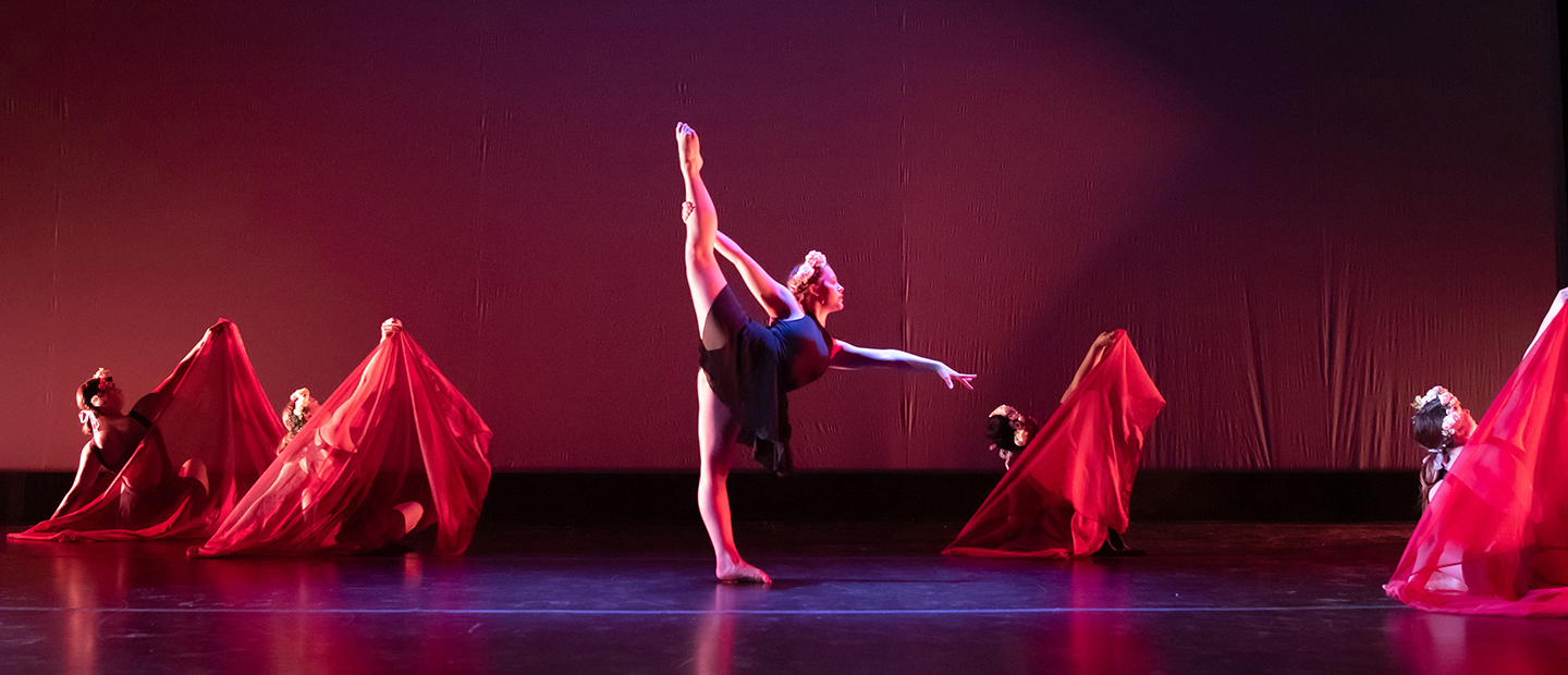 图像的一个舞者与她的腿延伸和四个舞者在背景