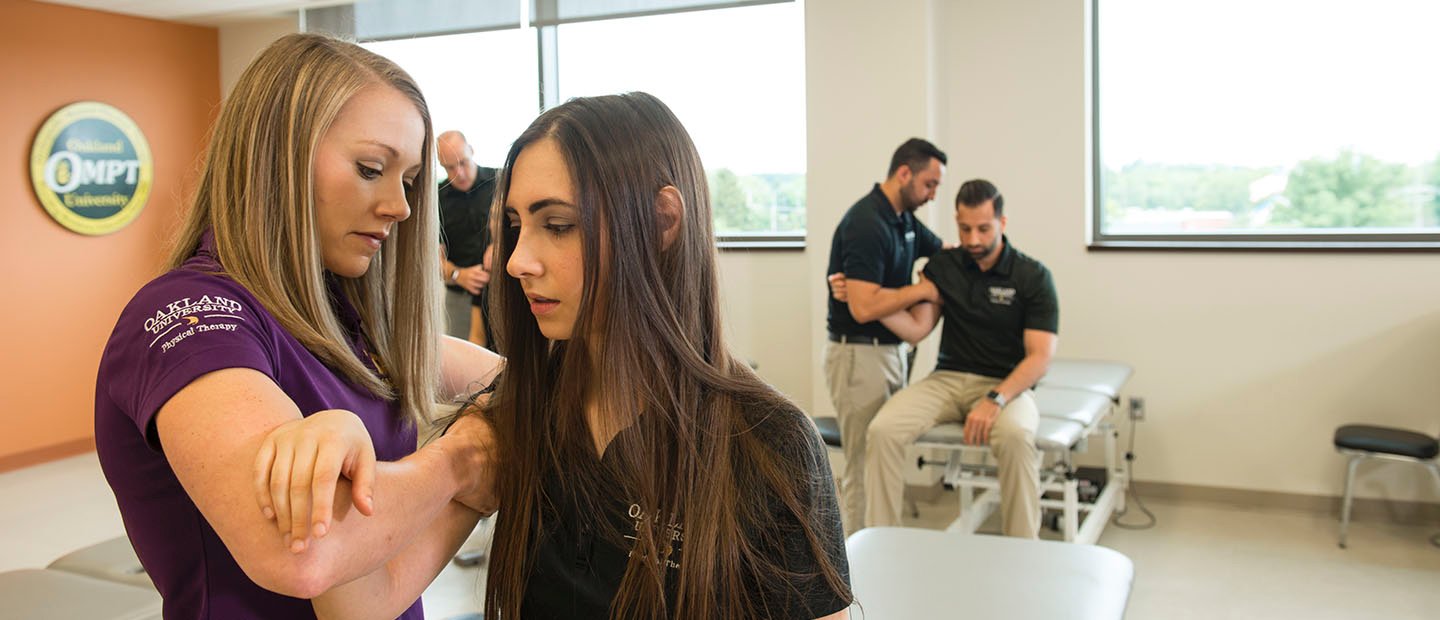 物理治疗师工作在一个年轻女人的肩膀上一个诊所