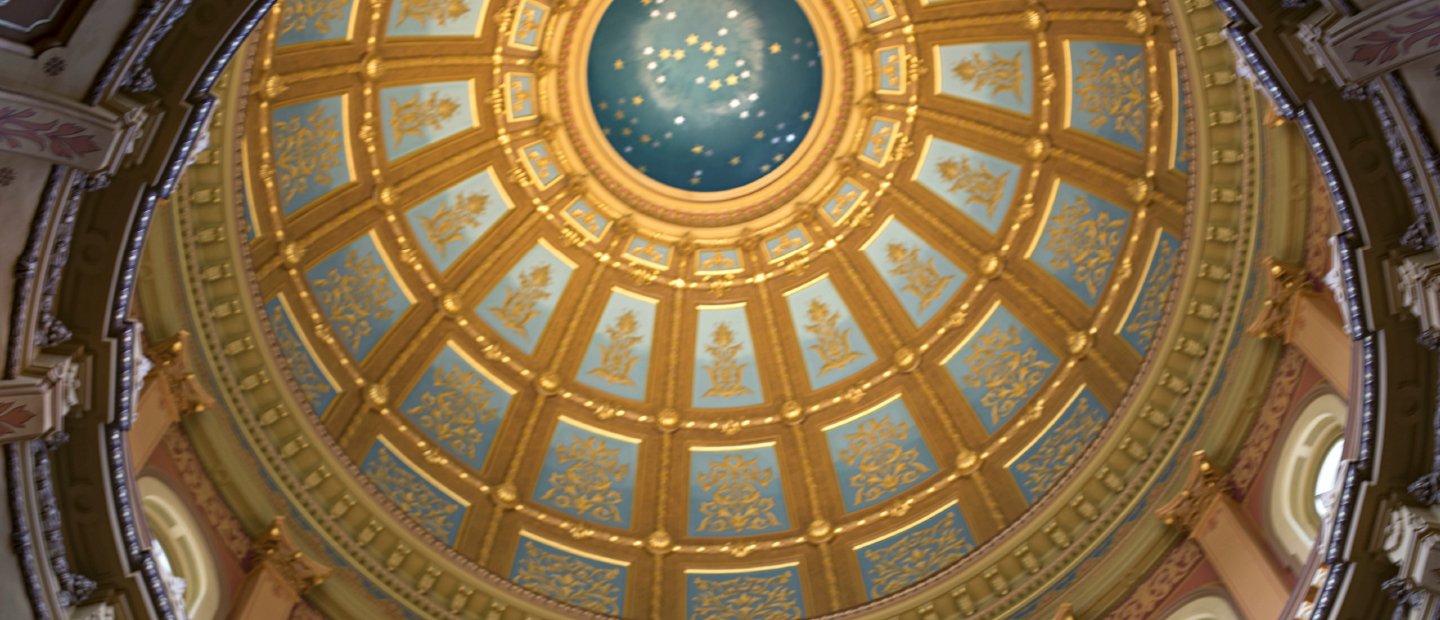 一张仰望着华丽的蓝色和金色圆顶天花板的照片。