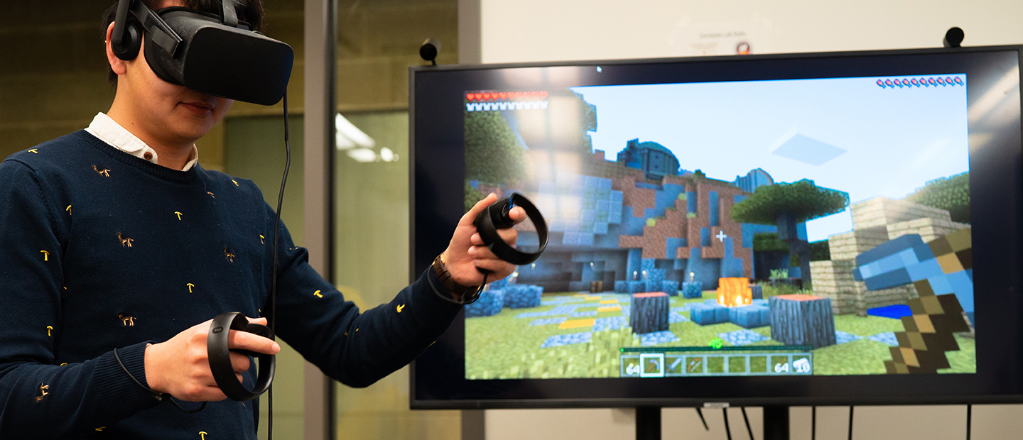 学生戴上虚拟现实的护目镜在显示器的前面