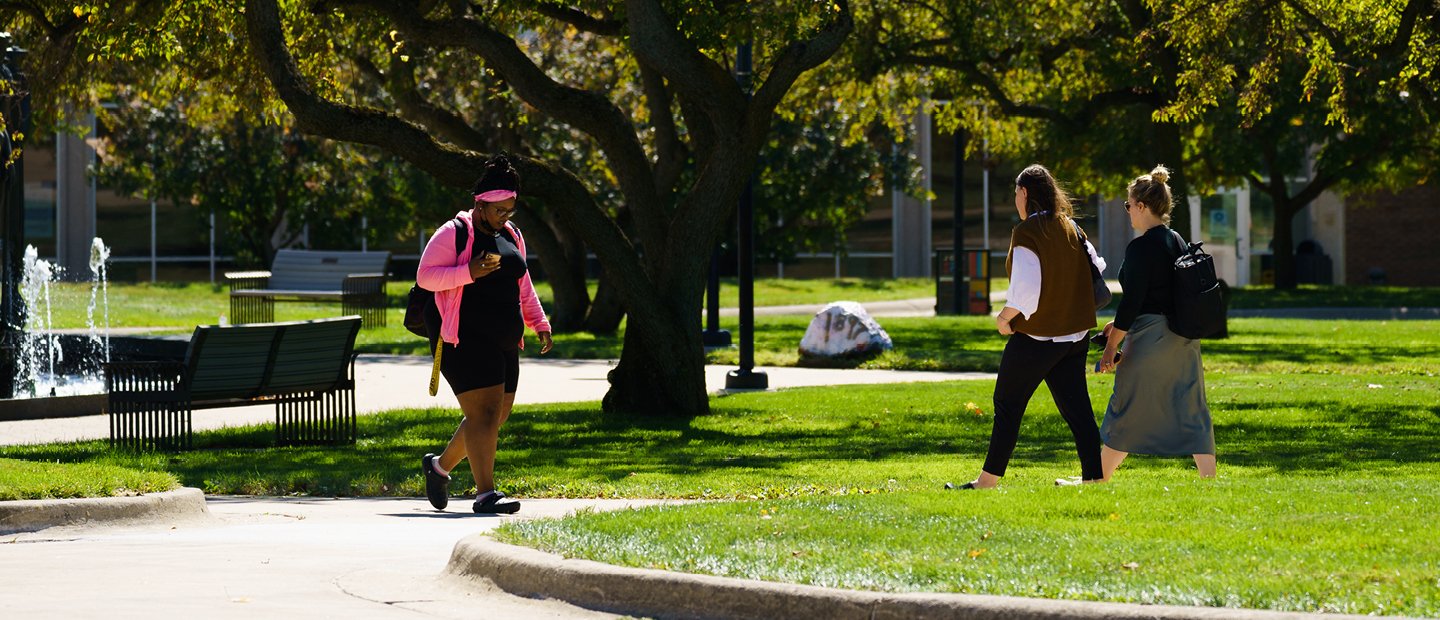 学生走在前面的喷泉在夏天在奥克兰大学的校园。万博ManBetX登录